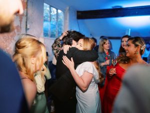 bride hugging guests amidst dancing guests